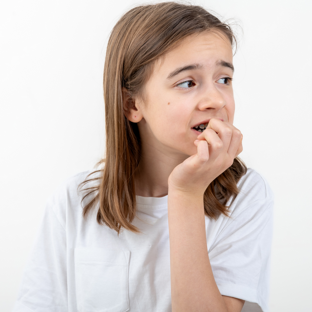 Une jeune ado anxieuse se ronge les ongles